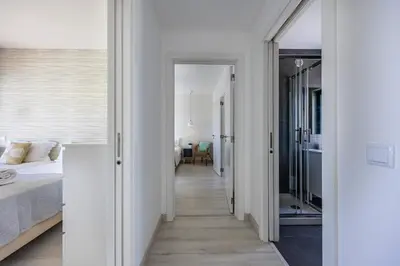 a bedroom with white walls and a bed and a hallway at Villa Back Loop in Sagres