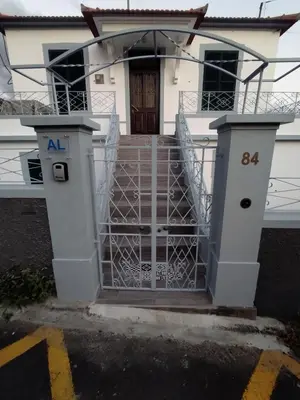a gate in front of a white house at Bus Stop House 84 in Funchal