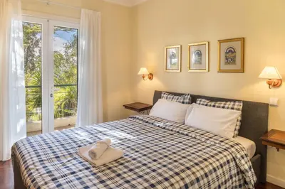 a bedroom with a bed with a blue and white checked blanket at Villa Echium T2 in Caniço