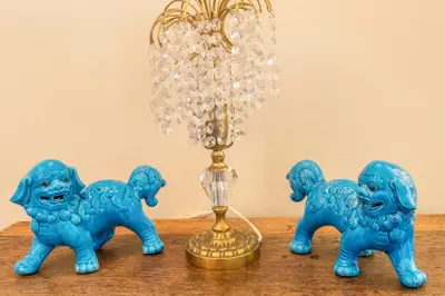 three blue glass figurines on a table with a lamp at Villa Echium T2 in Caniço