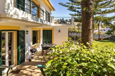a house with a patio and a tree at Villa Echium T1 in Caniço