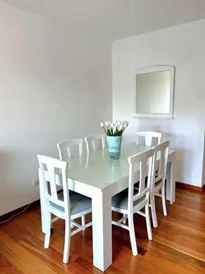 a white table with chairs and a vase of flowers on it at Ocean Pearl Apartment V in Funchal
