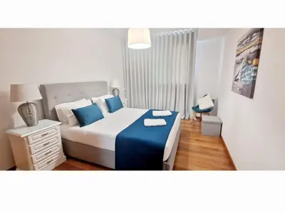 a bedroom with a large bed with blue pillows at Ocean Pearl Apartment V in Funchal