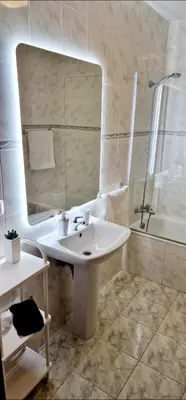 a bathroom with a sink and a mirror and a tub at Ocean Pearl Apartment V in Funchal