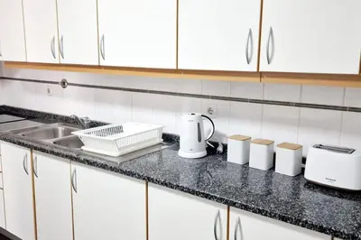 a kitchen counter with a sink and white cabinets at Ocean Pearl Apartment V in Funchal