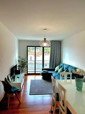 a living room with a blue couch and a table at Ocean Pearl Apartment V in Funchal