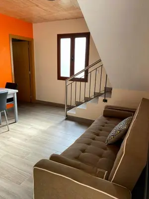 a living room with a couch and a staircase at casa caminho da praia in Porto da Cruz