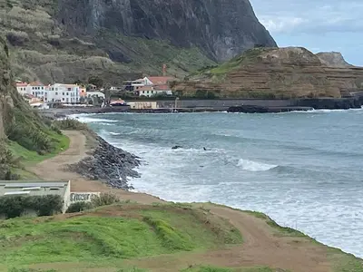 a view of a beach with houses and the ocean at casa caminho da praia in Porto da Cruz