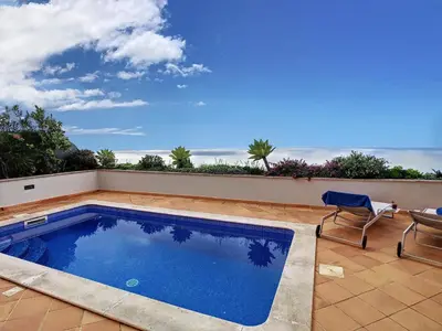 a swimming pool on a patio with two chairs at Ocean 59 by LovelyStay in Funchal