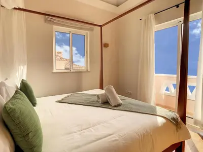 a bedroom with a large bed with two windows at Ocean 59 by LovelyStay in Funchal