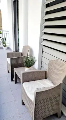 three wicker chairs and a table on a balcony at Ocean Pearl Apartment K in Funchal