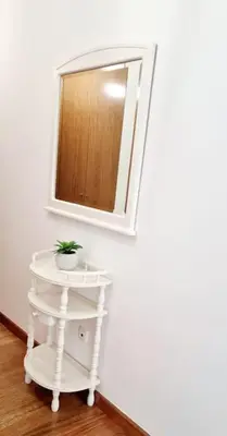 a small white table with a mirror on a wall at Ocean Pearl Apartment M in Funchal