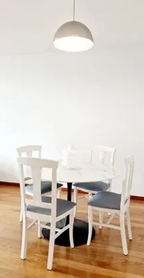 a white dining room table with chairs and a light fixture at Ocean Pearl Apartment M in Funchal