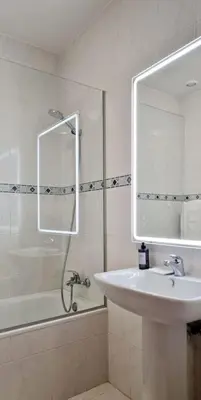 a bathroom with a sink and a shower with a mirror at Ocean Pearl Apartment M in Funchal