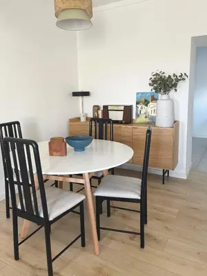 a dining room table with chairs and a kitchen at Casa Sagres T2 - 3 minutos a pé Praia da Mareta in Sagres