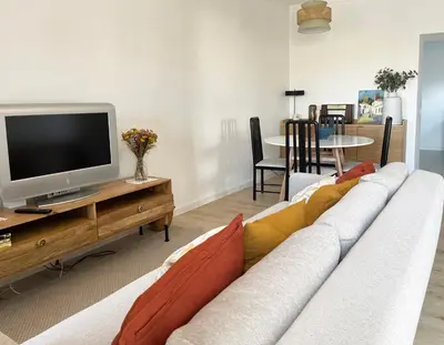 a living room with a couch and a tv at Casa Sagres T2 - 3 minutos a pé Praia da Mareta in Sagres