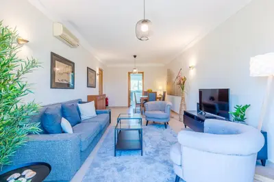 a living room with blue couches and a tv at Fairviews Village - Boavista Resort in Lagos in Lagos