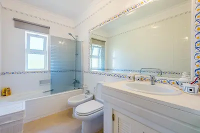 a bathroom with a sink and a toilet and a mirror at Fairviews Village - Boavista Resort in Lagos in Lagos
