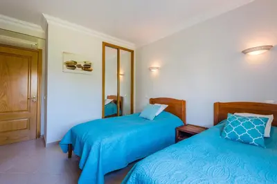 a bedroom with two beds with blue sheets and a door at Fairviews Village - Boavista Resort in Lagos in Lagos