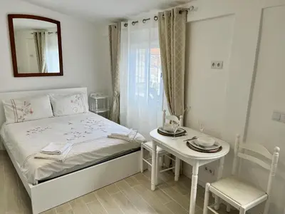 a small white bedroom with a bed and a table at Modern Minimalist Studio with Essential Comfort in Funchal