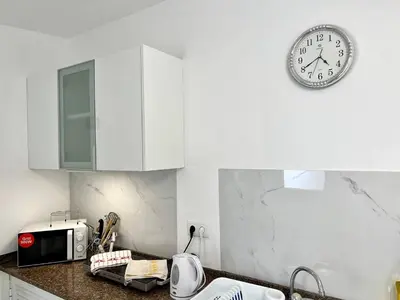 a clock on a wall above a kitchen counter at Modern Minimalist Studio with Essential Comfort in Funchal