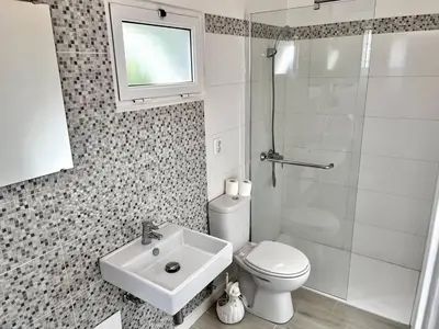 a bathroom with a toilet and a sink and a shower at Modern Minimalist Studio with Essential Comfort in Funchal