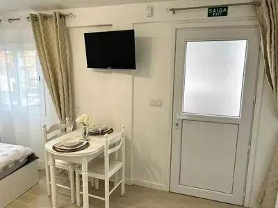 a room with a table and a door with a television at Modern Minimalist Studio with Essential Comfort in Funchal