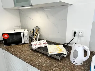 a kitchen counter with a microwave on a counter top at Modern Minimalist Studio with Essential Comfort in Funchal