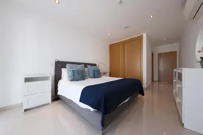 a bedroom with a large bed with blue pillows at Porto de Mos 105 by Destination Algarve in Lagos