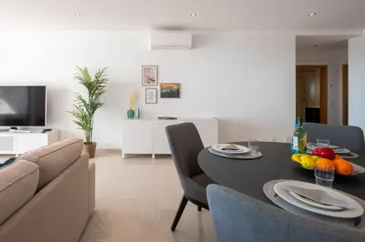 a living room with a dining room table and a couch at Porto de Mos 105 by Destination Algarve in Lagos