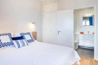 a bedroom with a white bed with blue and white pillows at Modern and cozy Apartment in Funchal