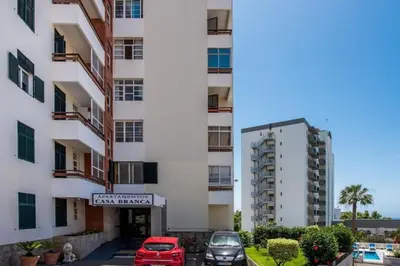 two cars parked in front of a building at Modern and cozy Apartment in Funchal