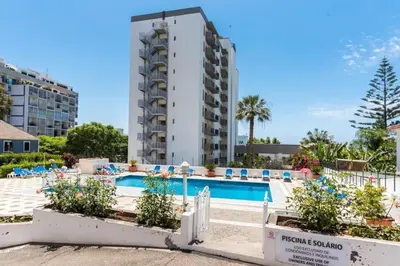 a hotel with a swimming pool in front of a building at Modern and cozy Apartment in Funchal
