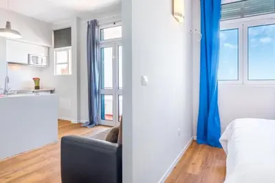 a bedroom with a bed and a kitchen with a window at Modern and cozy Apartment in Funchal