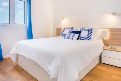 a bedroom with a white bed with blue and white pillows at Modern and cozy Apartment in Funchal