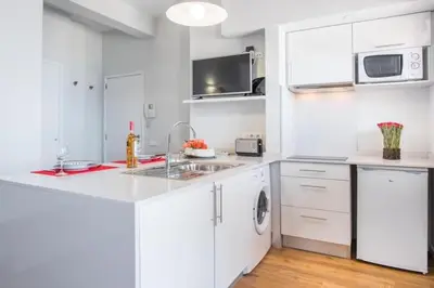 a white kitchen with a sink and a microwave at Modern and cozy Apartment in Funchal