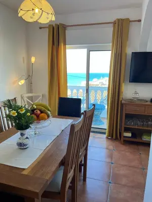 a dining room with a table with a view of the ocean at Casa Pedro in Salema - Oceanview & beach in Salema