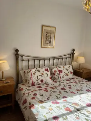 a bedroom with a bed with a floral comforter and two lamps at Casa Pedro in Salema - Oceanview & beach in Salema