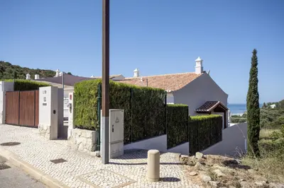 a house with a hedge in front of a house at 401 Villa Salemar in Salema