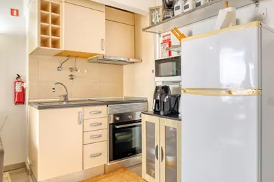 a small kitchen with a refrigerator and a sink at Lido Sunset, a Home in Madeira in Funchal
