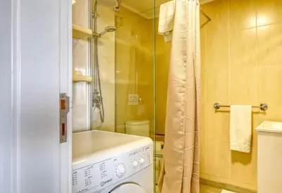 a bathroom with a washing machine and a shower at Lido Sunset, a Home in Madeira in Funchal