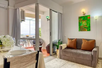 a living room with a couch and a table at Lido Sunset, a Home in Madeira in Funchal