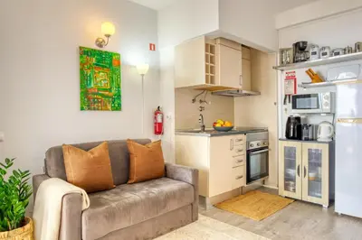a living room with a couch and a kitchen at Lido Sunset, a Home in Madeira in Funchal
