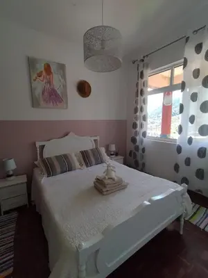 a bedroom with a white bed and a window at Sea Mountain House in Machico