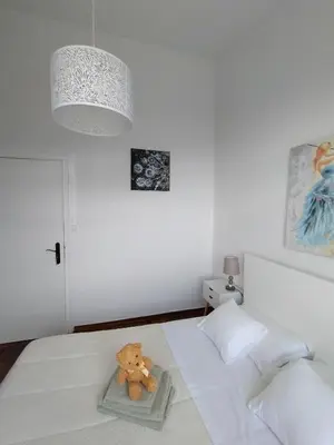 a teddy bear sitting on a bed in a bedroom at Sea Mountain House in Machico