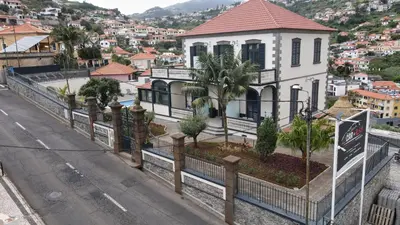 a white house with a fence next to a street at Sea and Sun 4 You - Villa Oliveira in Funchal