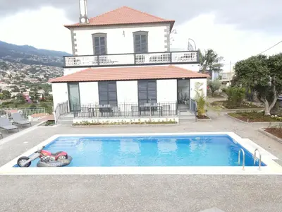 a house with a swimming pool in front of a house at Sea and Sun 4 You - Villa Oliveira in Funchal