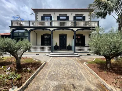 a large white house with trees in front of it at Sea and Sun 4 You - Villa Oliveira in Funchal