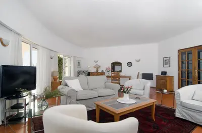 a living room with white furniture and a tv at Villa Camena, private pool, sea view, residential area outside of the village Praia da Luz in Luz