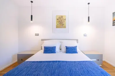 a white bed with blue pillows in a bedroom at Magic Home, everything you need. in Funchal